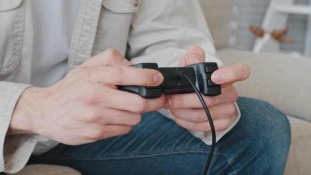 Detailní nerozeznatelný běloch neznámý muž muž v neformálním oblečení drží ovladač joystick v ruce hraje videohry konzole on-line doma sedí na gauči baví, videohry koncept - Záběry, video