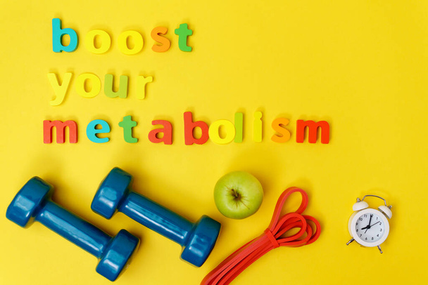 Zvýšit metabolismus sporty, činky, jablko na žlutém pozadí horní pohled. - Fotografie, Obrázek