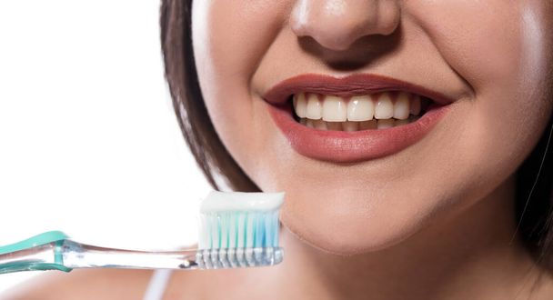 mooie jonge vrouw met tandenborstel op witte achtergrond - Foto, afbeelding