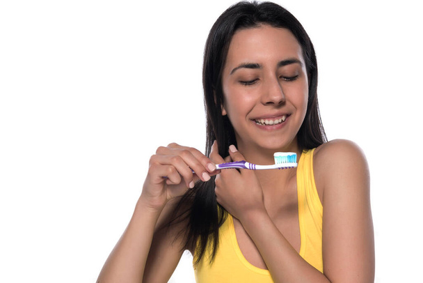 hermosa joven con cepillo de dientes sobre fondo blanco - Foto, imagen