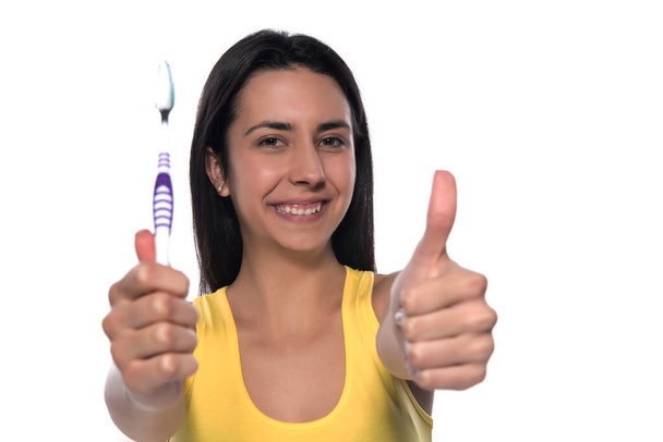 young woman with toothbrush and dental floss isolated on white background - 写真・画像