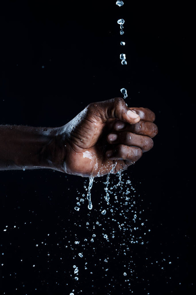 African man hands interacting with water. - Zdjęcie, obraz