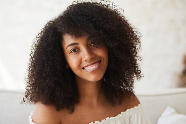 Een serene, jonge gemengde ras vrouw met een heldere huid en een mooie glimlach - Foto, afbeelding
