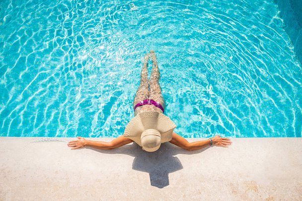 Młoda blondynka relaksująca się w basenie w kurorcie spa - koncepcja relaksu - Zdjęcie, obraz