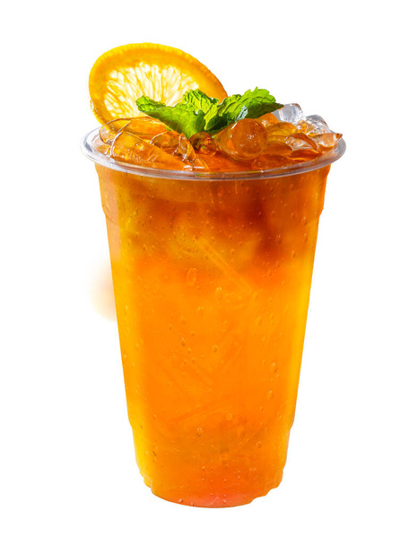 Thé glacé mélangé avec du jus d'orange avec des tranches d'orange et des feuilles de menthe sur isolées. - Photo, image