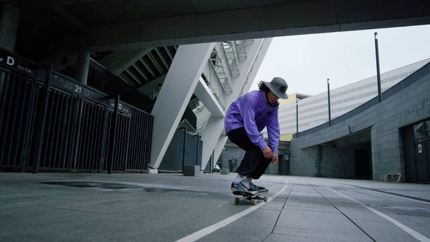 Actieve hipster jumping op skateboard outdoor. Skater jongen balanceren op longboard. - Foto, afbeelding
