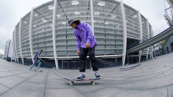Sportieve hipster balanceert op longboard bij City Street. Skater springen op skate. - Foto, afbeelding
