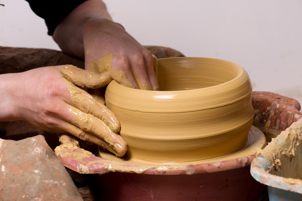 handen van een pottenbakker, het creëren van een aarden kruik - Foto, afbeelding