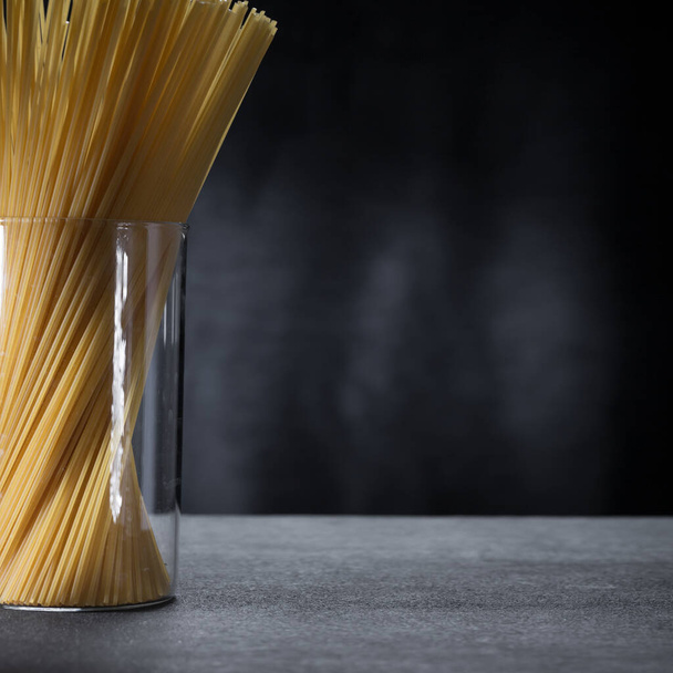 minimalistic image of spaghetti pasta in a glass jar close-up. - Foto, immagini
