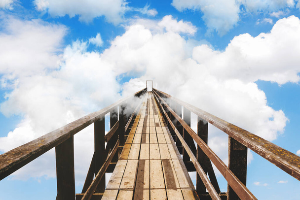 Tahta köprü bulutlara karışıyor. Gökyüzünde bulutlar ve bir köprü. Bilinmeyen, başarı ya da korku kavramı - Fotoğraf, Görsel