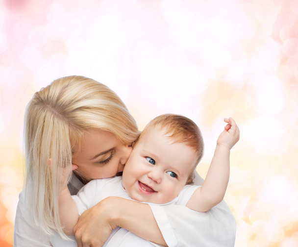 glückliche Mutter küsst lächelndes Baby - Foto, Bild