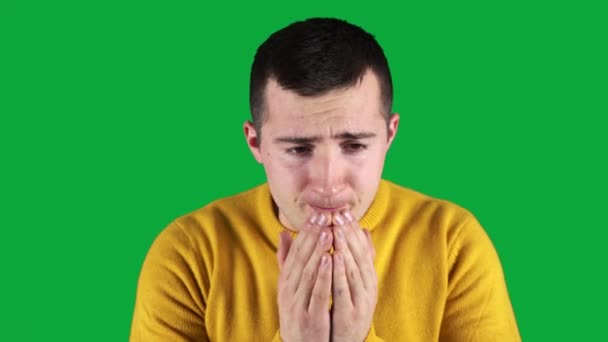 homem em um suéter amarelo espirra em um fundo verde - Filmagem, Vídeo