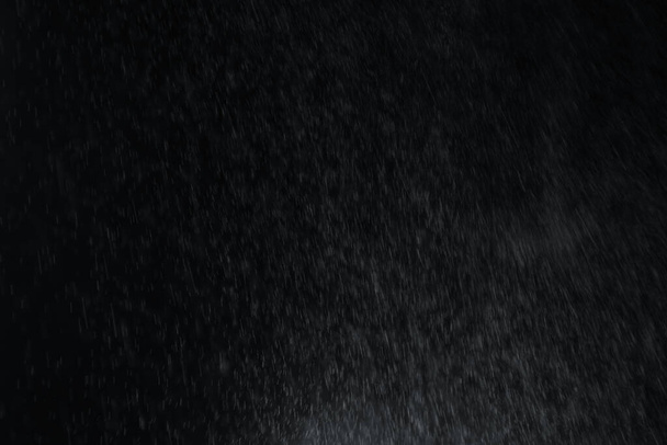 Water splash from the above like raining overlay effect on black background. - Photo, image