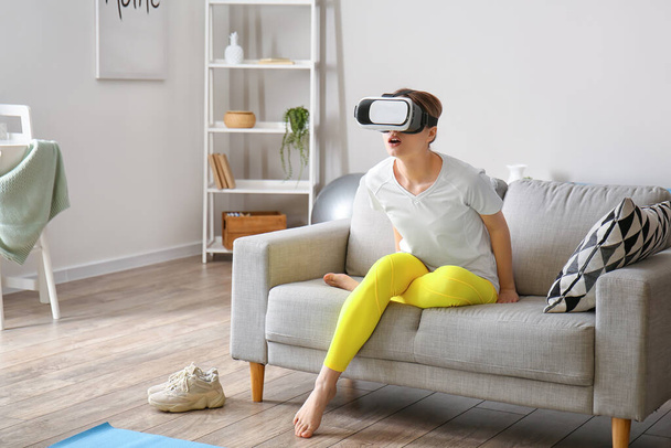Young woman with virtual reality glasses at home - Valokuva, kuva