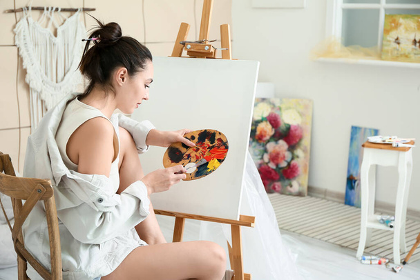 ワークショップにおける若い女性アーティストの絵画 - 写真・画像