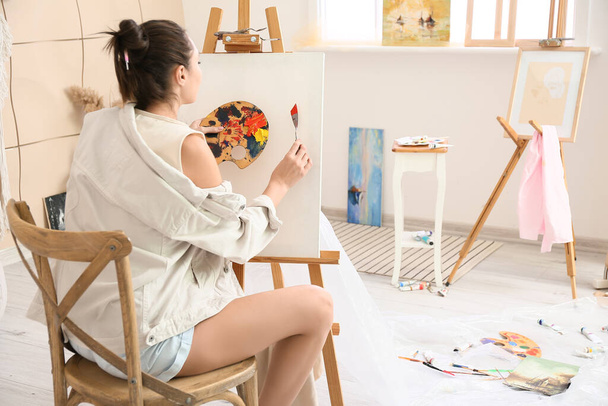 Young female artist painting in workshop - Photo, Image