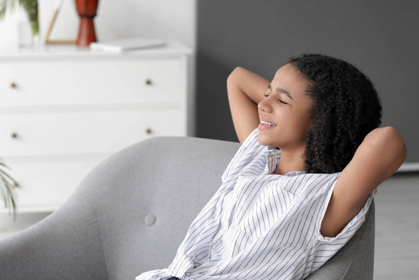 Afro-Amerikalı kız evdeki koltukta dinleniyor. - Fotoğraf, Görsel