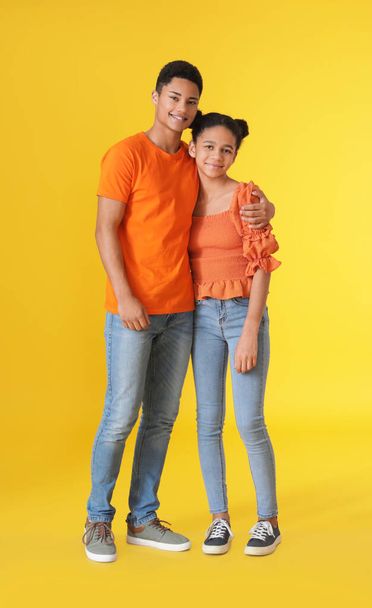 African-American brother and sister on color background - Foto, Bild