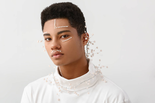 Retrato creativo del guapo chico afroamericano sobre fondo claro - Foto, Imagen