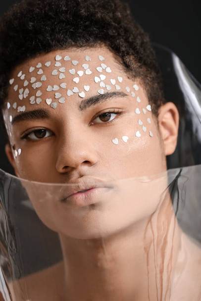 Retrato creativo del guapo chico afroamericano sobre fondo oscuro - Foto, imagen