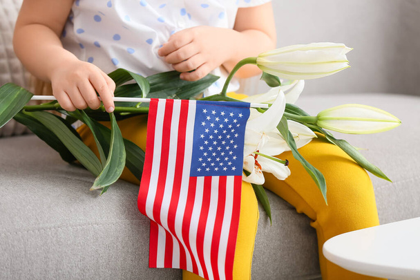Petite fille avec drapeau américain et fleurs à la maison. Célébration commémorative - Photo, image
