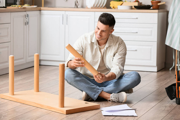 Junger Mann baut Möbel zu Hause zusammen - Foto, Bild