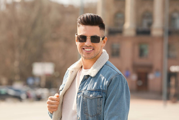 Молодой человек в стильных солнечных очках на улице - Фото, изображение