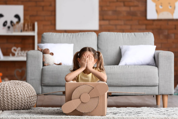 Little girl playing with cardboard airplane at home - Photo, Image