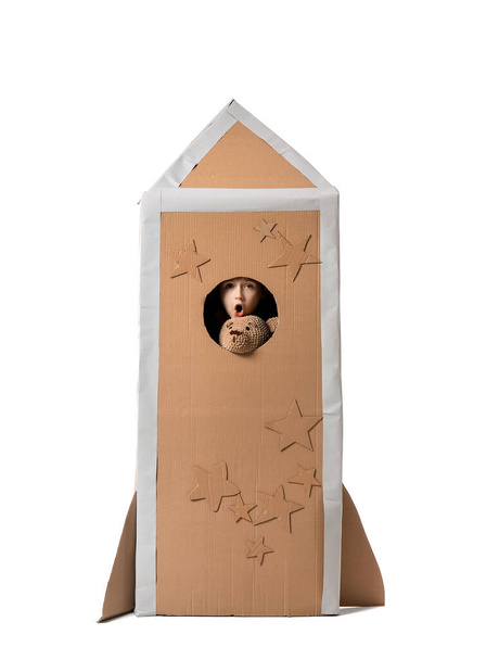 шокированный маленький мальчик в картонной ракете на белом фоне - Фото, изображение