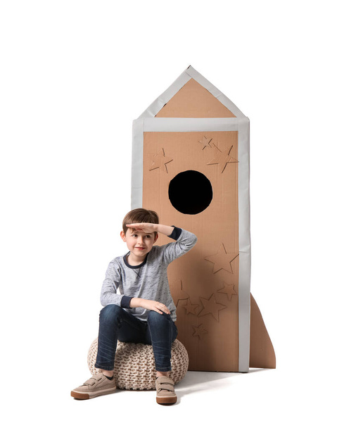 Милий маленький хлопчик з картонною ракетою на білому тлі
 - Фото, зображення