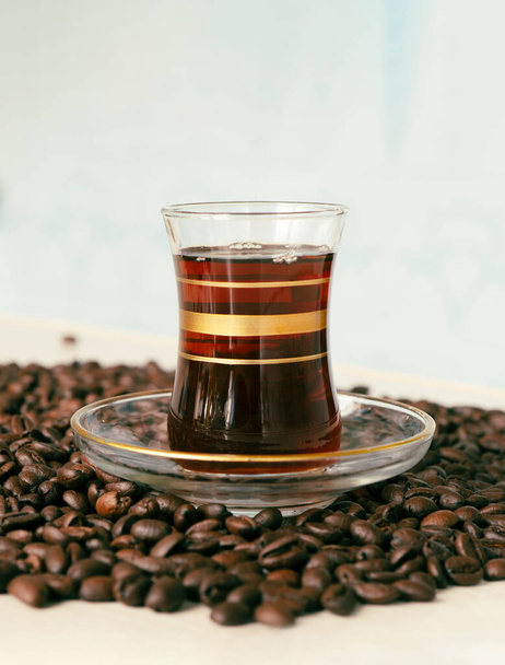 Egy üveg bögre a hagyományos török stílusú fekete kávé áll a kávébab fekszik az asztalon. Finom energiaital.. - Fotó, kép