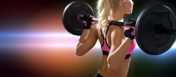sporty woman exercising with barbell from back - Foto, immagini