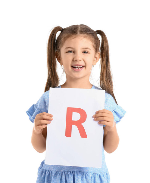 Little girl holding paper sheet with letter R on white background - 写真・画像