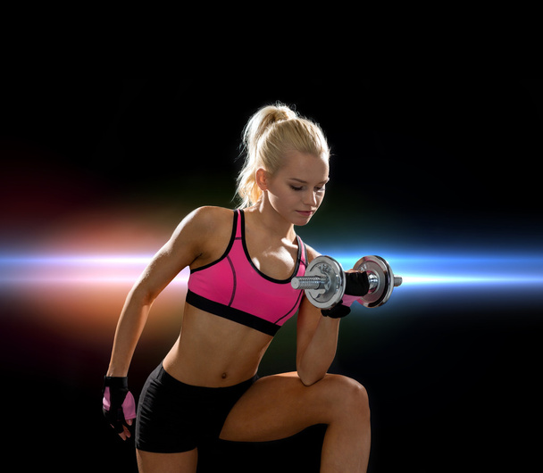 young sporty woman with heavy steel dumbbell - Foto, Imagen