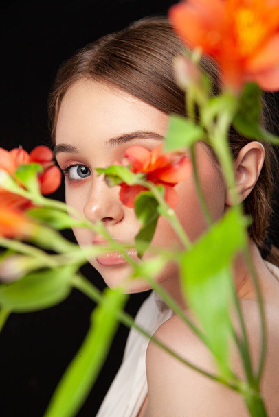 Elegant young female model with delicate flowers - Foto, afbeelding