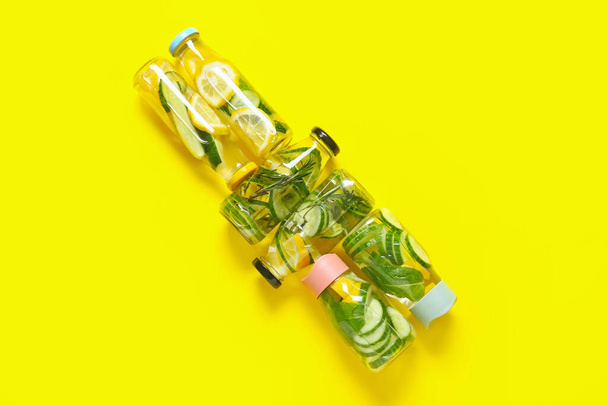 Bottles with cucumber lemonade on color background - Photo, Image