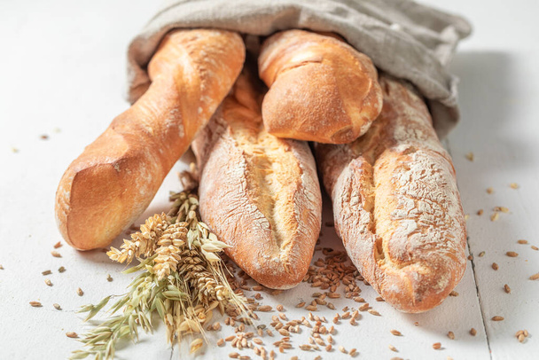 Brown baguettes made of whole grains. Country kitchen or bakery. Pieces of baguette. - 写真・画像