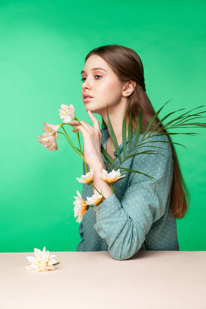 Young woman with flowers in blouse sleeves - 写真・画像