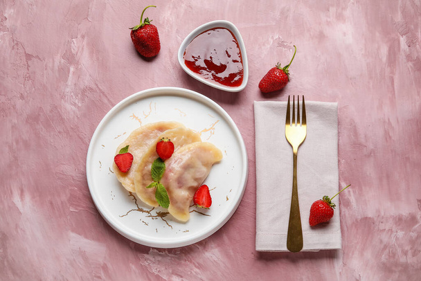 Assiette avec de savoureuses boulettes de fraises et sauce sur fond de couleur - Photo, image