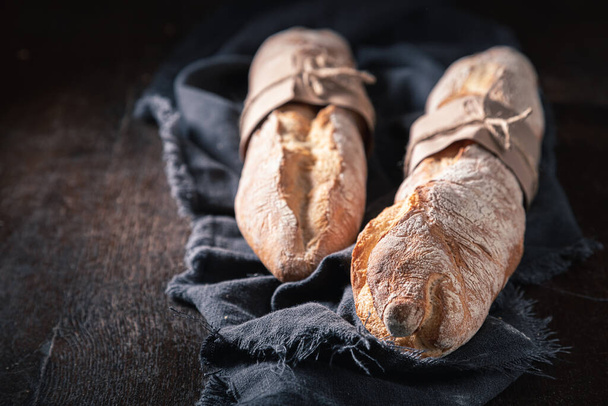 Brown baguettes for healthy breakfast. Country kitchen or bakery. Pieces of baguette. - 写真・画像