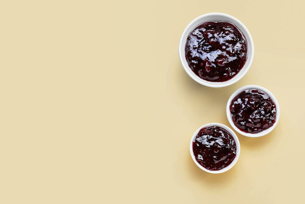 Bowls with tasty cherry jam on color background - Foto, imagen