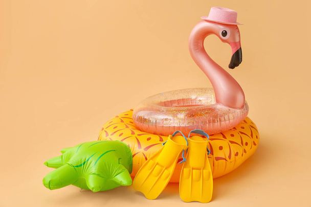 Inflatable rings, hat and flippers on color background - Photo, Image