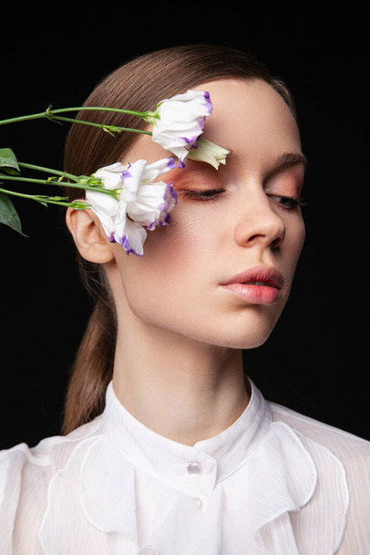 Elegant young female model with delicate flowers - Φωτογραφία, εικόνα