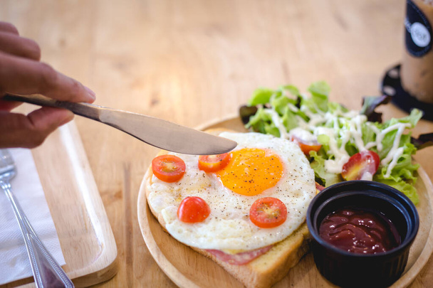 jedzenie nóż przygotowuje uderzyć smażone jajko na ser kanapkowy szynka służyć z drewnianą płytą - Zdjęcie, obraz