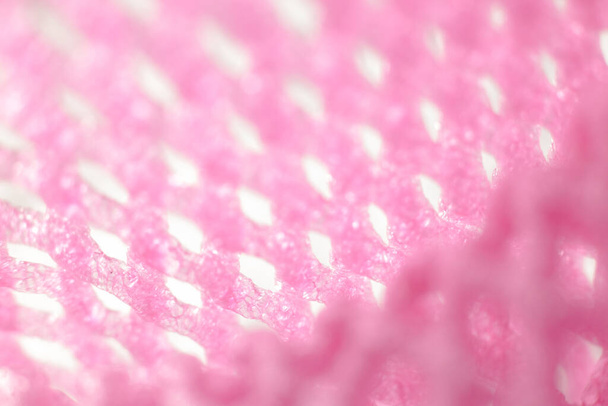 Macro closeup inside soft pink fruit net with light shine on - Фото, изображение
