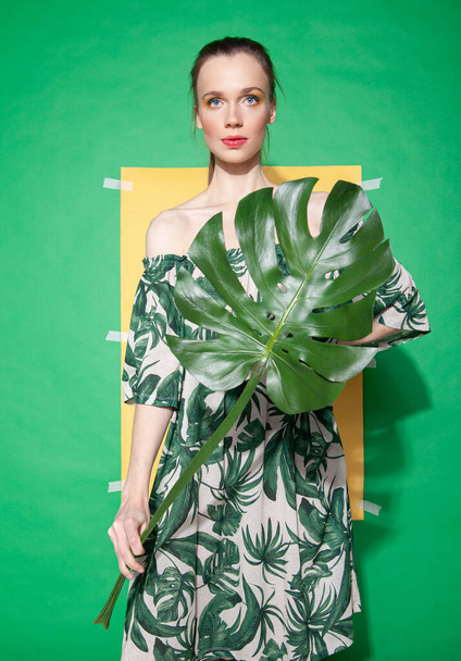 Young woman in summer dress holding leaf - Fotó, kép