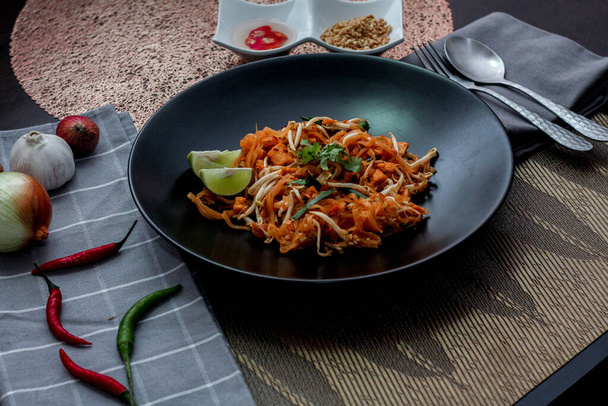 タイ料理パッドタイ料理パッドタイ料理ブラックプレートにライムと調味料. - 写真・画像