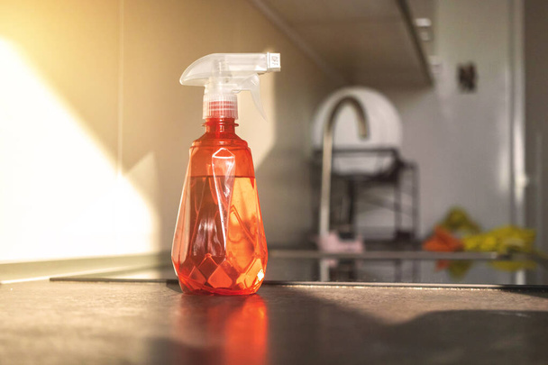 Розпилювальна пляшка з водою на кухонному столі, концепт-фото прибирання кухні
 - Фото, зображення