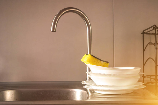 купа чистого посуду з губкою в кухонній раковині, концепція домашнього завдання
  - Фото, зображення