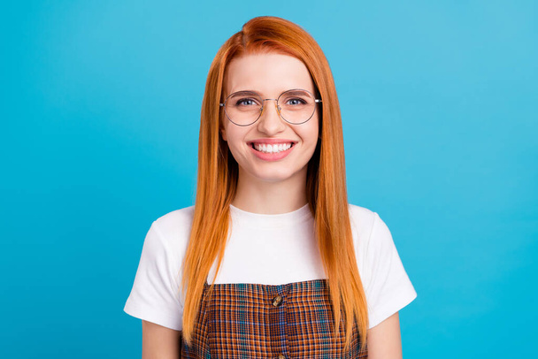 Photo of pretty charming orange hair lady wear plaid overall spectacles smiling isolated blue color background - Photo, Image